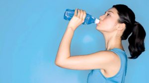 Спортсмен пьет воду после заплыва